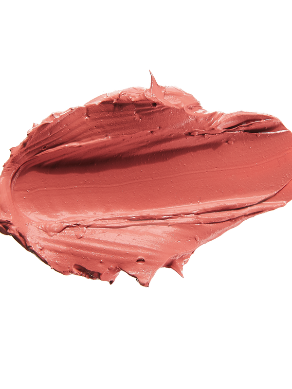 A thick smear of muted coral pink Mirage matte lipstick on white, with a smooth centre and raised, creamy ridges around the edges.