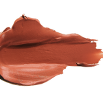 A thick smear of warm orange brown Mojave matte lipstick on white, with a smooth centre and raised, creamy ridges around the edges.