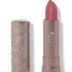 100% Pure Plume Pink matte lipstick with a slanted dusty rose pink tip extended from a taupe tube; its matching cap stands beside it with white botanical line drawings.