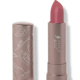 100% Pure Plume Pink matte lipstick with a slanted dusty rose pink tip extended from a taupe tube; its matching cap stands beside it with white botanical line drawings.