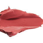 A thick smear of dusty rose pink Plume Pink matte lipstick on white, with a smooth centre and raised, creamy ridges around the edges.