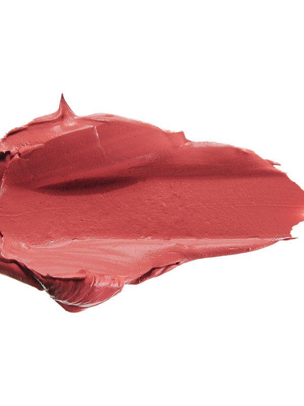 A thick smear of dusty rose pink Plume Pink matte lipstick on white, with a smooth centre and raised, creamy ridges around the edges.