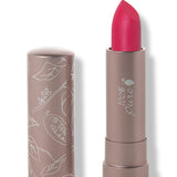 100% Pure Protea matte lipstick with a slanted raspberry pink tip extended from a taupe tube; its matching cap stands beside it with white botanical line drawings.