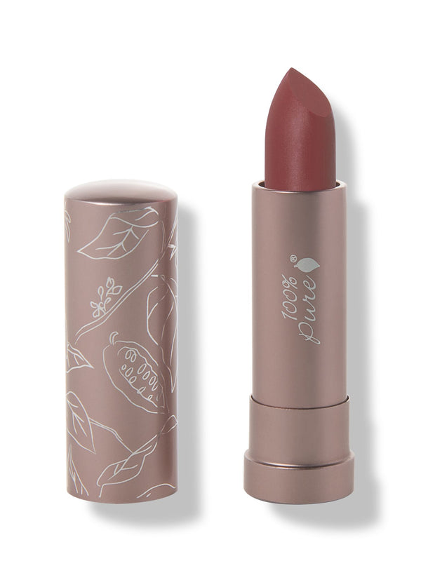 100% Pure Savanna matte lipstick with a slanted brownish brick red tip extended from a taupe tube; its matching cap stands beside it with white botanical line drawings.