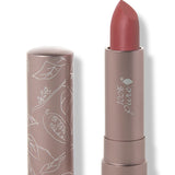 100% Pure Sahara matte lipstick with a slanted muted brick rose tip extended from a taupe tube; its matching cap stands beside it with white botanical line drawings.
