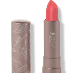 100% Pure Strawberry Cactus matte lipstick with a slanted bright coral red tip extended from a taupe tube; its matching cap stands beside it with white botanical line drawings.