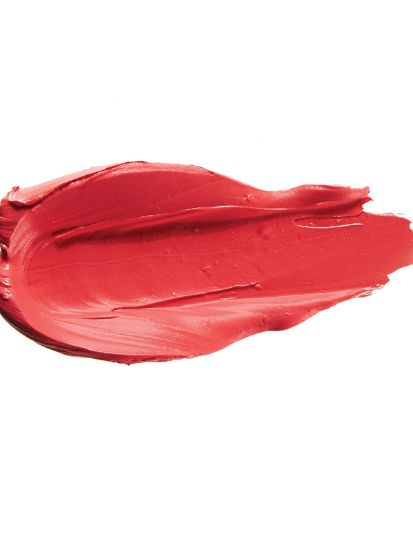 A thick smear of bright coral red Strawberry Cactus matte lipstick on white, with a smooth centre and raised, creamy ridges around the edges.