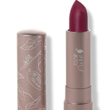 100% Pure Winecup matte lipstick with a slanted deep berry red tip extended from a taupe tube; its matching cap stands beside it with white botanical line drawings.