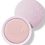 An open pale pink compact of Moonstone Glow luminiser, showing pearly pink powder embossed with the 100% Pure logo and a matching patterned lid behind it.