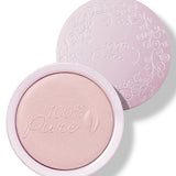 An open pale pink compact of Moonstone Glow luminiser, showing pearly pink powder embossed with the 100% Pure logo and a matching patterned lid behind it.