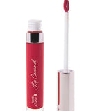 100% Pure Lip Caramel in Cherry Cordial: an open clear tube of bright berry-red liquid lipstick beside a white applicator wand with a reflective silver-pink cap and a tip coated in the same shade.