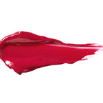 Cherry Cordial 100% Pure Lip Caramel swatch: thick, glossy bright berry-red liquid lipstick spread into an elongated smear, with raised ridges and a tapering streak at one end.