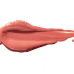 Rum Nougat 100% Pure Lip Caramel swatch: thick, glossy peach-rose liquid lipstick spread into an elongated smear, with raised ridges and a tapering streak at one end.