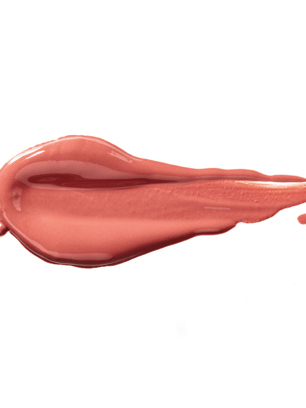 Rum Nougat 100% Pure Lip Caramel swatch: thick, glossy peach-rose liquid lipstick spread into an elongated smear, with raised ridges and a tapering streak at one end.