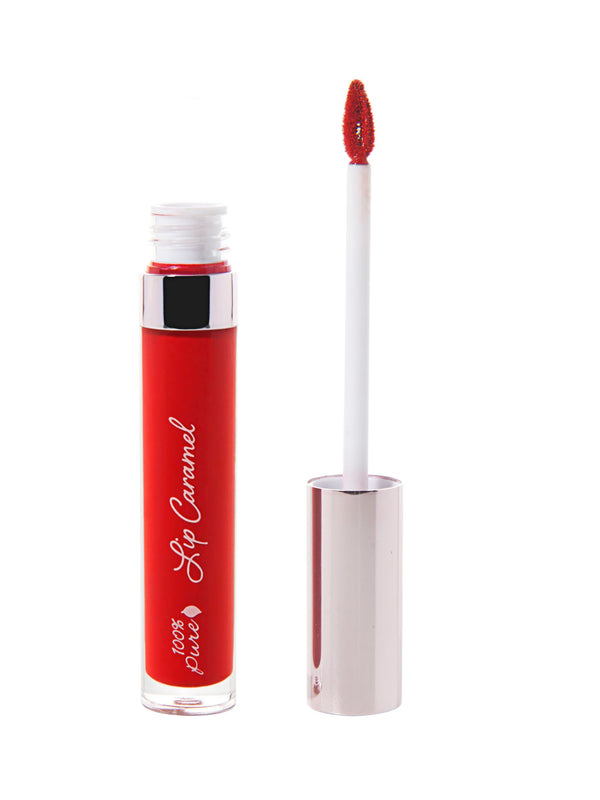 100% Pure Lip Caramel in Red Velvet: an open clear tube of rich red liquid lipstick beside a white applicator wand with a reflective silver-pink cap and a tip coated in the same shade.