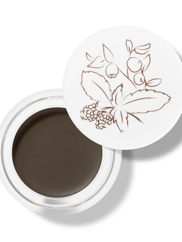 100% Pure Long Last Brows in Medium Brown: an open white pot filled with dark brown brow cream. A fine drawing of leaves and berries decorates the white lid resting behind the pot.