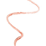 A thin peach-brown lip-liner swatch forms a tall wavy line on white. Fine parallel strokes and a lightly broken edge reveal the pencil texture.