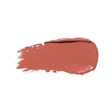 A horizontal swatch of Calendula lipstick in warm peach brown, with a softly glossy surface, a rounded end and fine brush marks at the opposite edge.