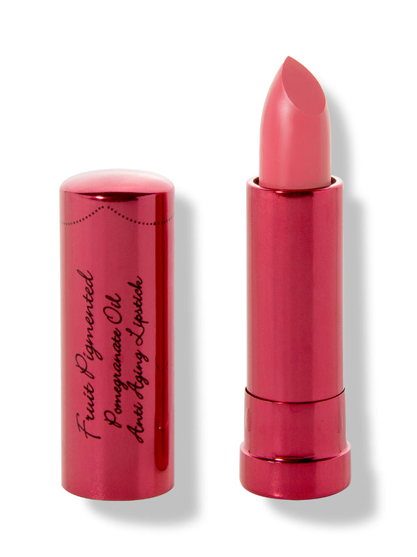 Magnolia lipstick with a slanted bright coral pink tip extended from a metallic pink tube; its matching cap with black cursive lettering stands beside it.