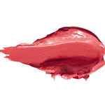 A thick smear of Magnolia lipstick in bright coral pink, with a smooth glossy centre, raised creamy ridges and a tapered end on white.
