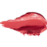 A thick smear of Magnolia lipstick in bright coral pink, with a smooth glossy centre, raised creamy ridges and a tapered end on white.