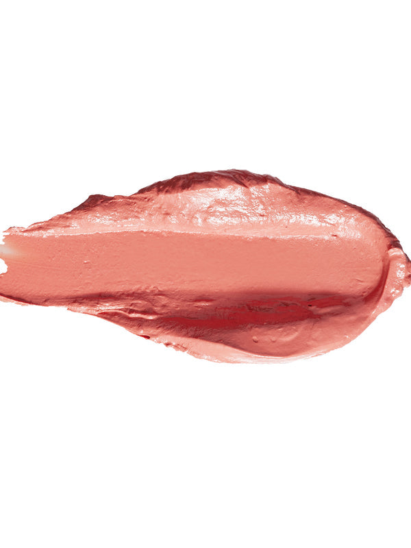 A thick smear of Peony lipstick in pale peach pink, with a smooth glossy centre and raised creamy edges on white.