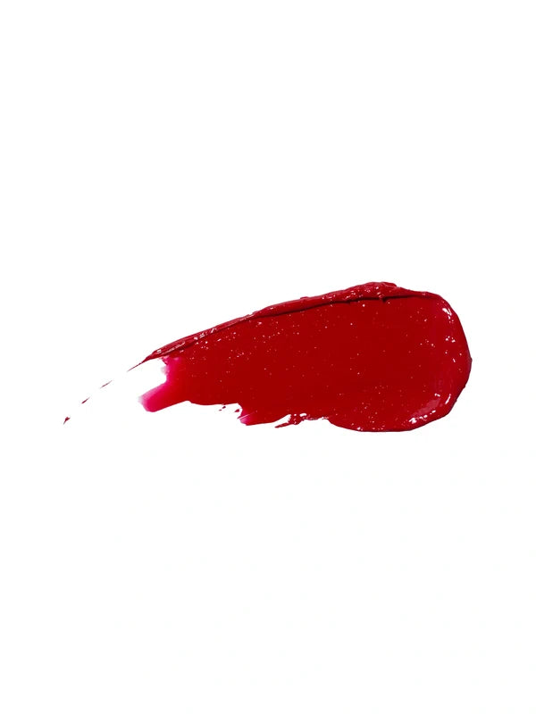 A glossy swatch of Poppy lipstick in rich red, with a rounded end and a narrow, streaked trail on white.
