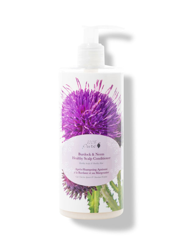 A white pump bottle of 100% Pure Burdock and Neem Healthy Scalp Conditioner has a large purple thistle and green leaves behind a pale pink oval label. The white pump points to the right.