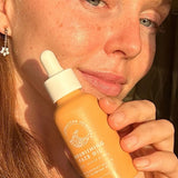 SunButter Nourishing Face Oil held beside face