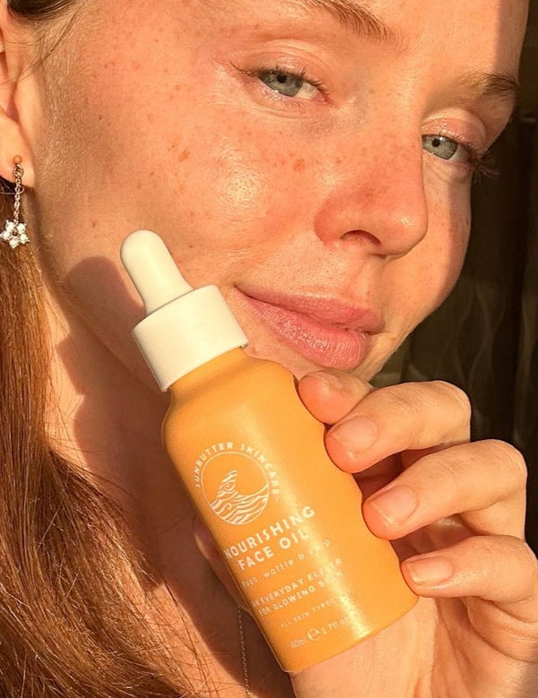 SunButter Nourishing Face Oil held beside face