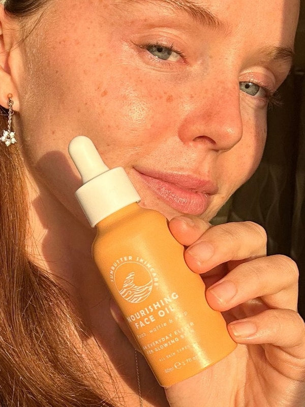 SunButter Nourishing Face Oil held beside face