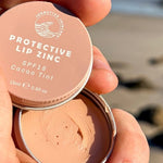 SunButter Cacao Tint Protective Lip Zinc open in hand
