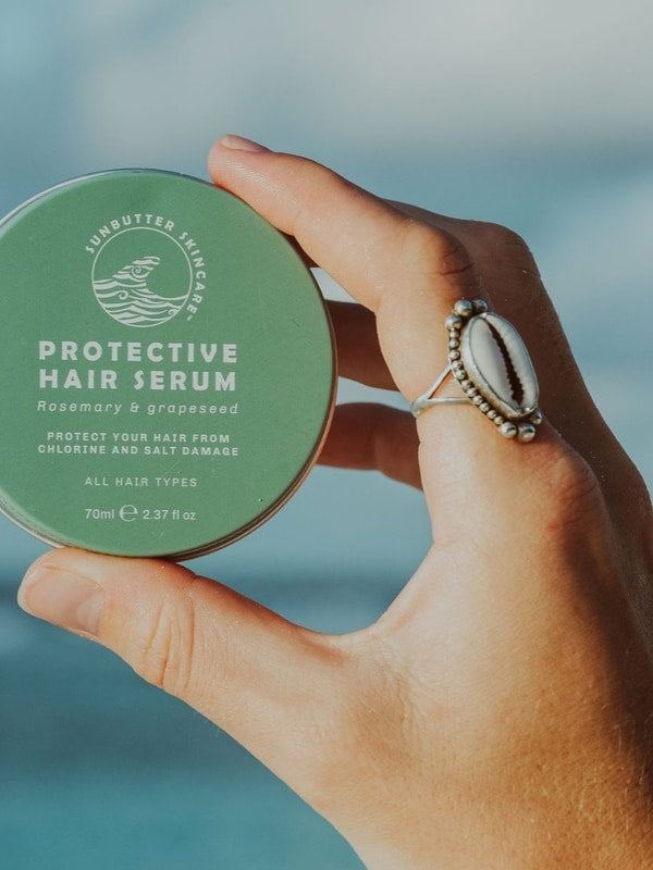 SunButter Protective Hair Serum held in hand