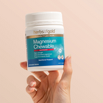 Hand holding the Herbs of Gold Magnesium Chewable tub