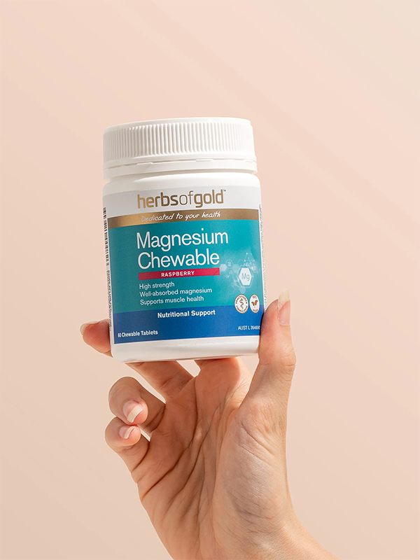Hand holding the Herbs of Gold Magnesium Chewable tub