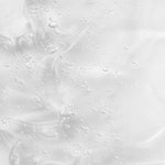 Creamy gel texture of KORA Organics Renewing Hand and Body Wash swatched against a peach background