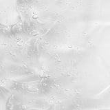 Creamy gel texture of KORA Organics Renewing Hand and Body Wash swatched against a peach background