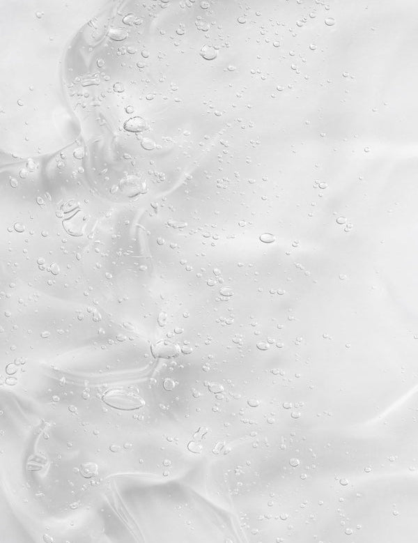 Creamy gel texture of KORA Organics Renewing Hand and Body Wash swatched against a peach background