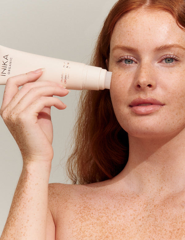 Model applying INIKA Organic Phytofuse Renew Cream Cleanser to her face