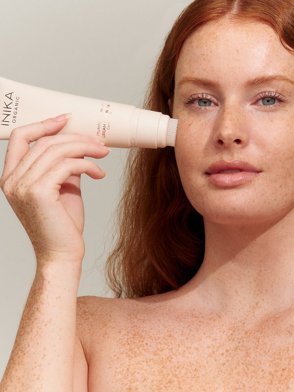 Model applying INIKA Organic Phytofuse Renew Cream Cleanser to her face