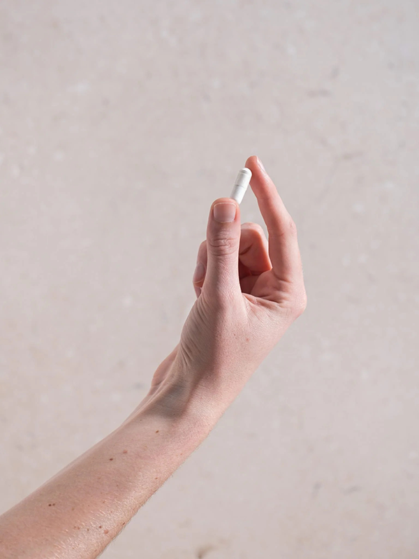 Hand holding a Herbs of Gold Magnesium Citrate 900 capsule