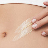 Model smoothing KORA Organics Nourishing Hand and Body Lotion onto her skin