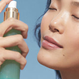 Model spraying KORA Organics Minty Mineral Hydration Mist on her face