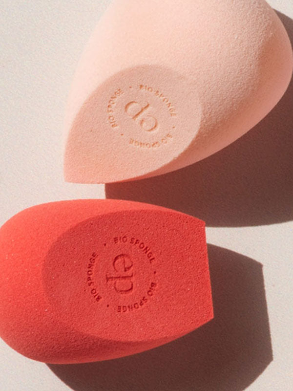 Ere Perez Bio All-Beauty Sponges in peach and coral lying in sunlight