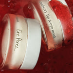 Two jars of Ere Perez Cranberry Lip and Eye Mask nestled in cranberry jam