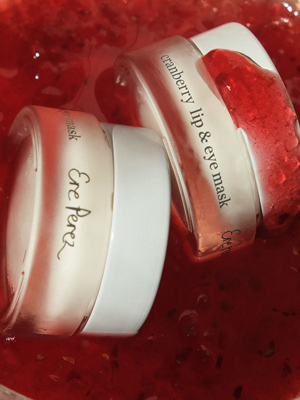 Two jars of Ere Perez Cranberry Lip and Eye Mask nestled in cranberry jam