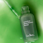Ere Perez Quandong Green Booster Serum pouring from an open green glass bottle with the dropper alongside
