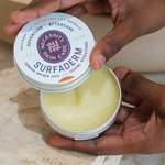 Open Necessity Surfaderm tin held in hands