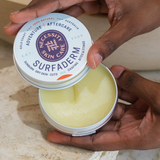 Open Necessity Surfaderm tin held in hands