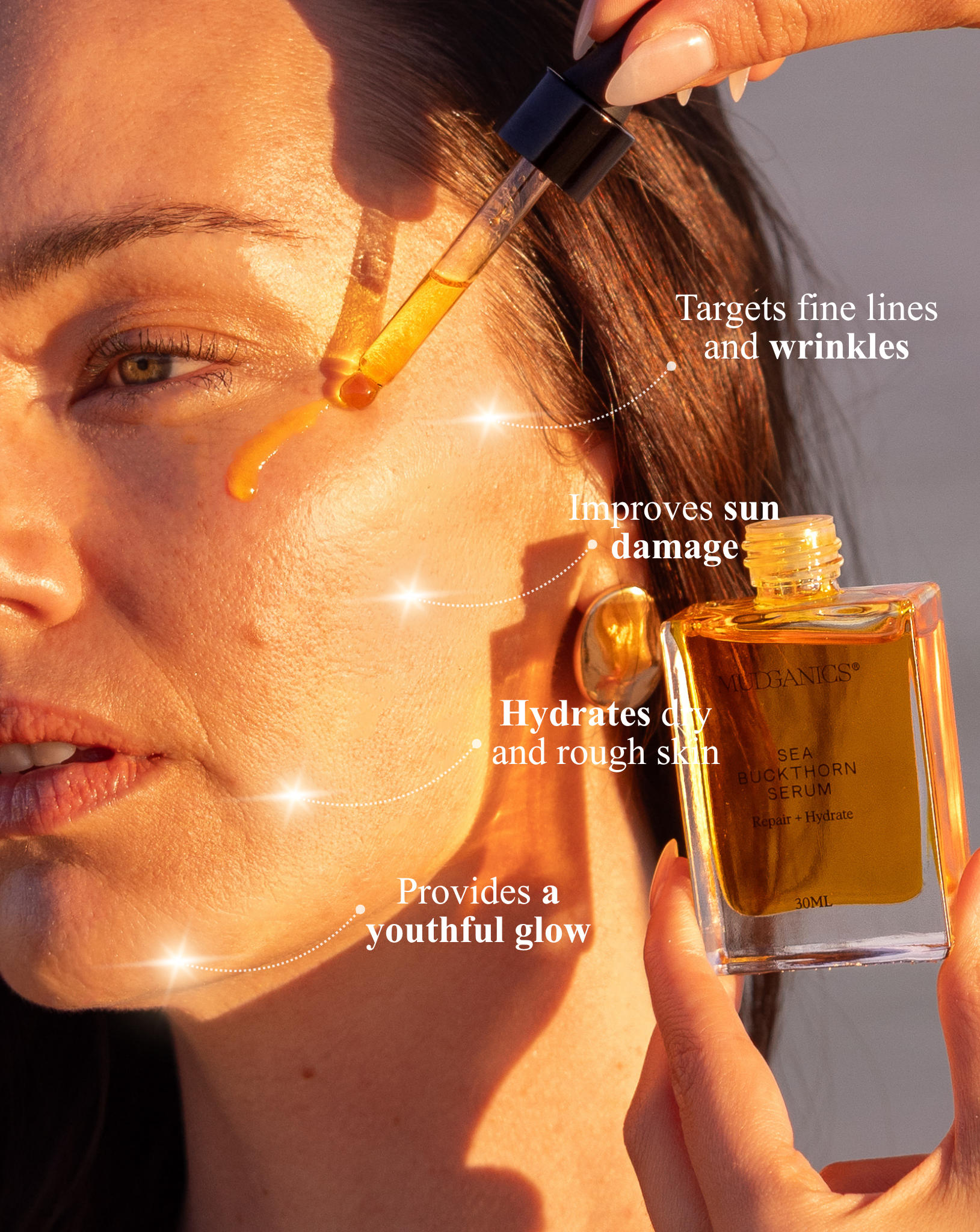 Woman applying Mud Organics Sea Buckthorn Serum to her face in warm sunlight